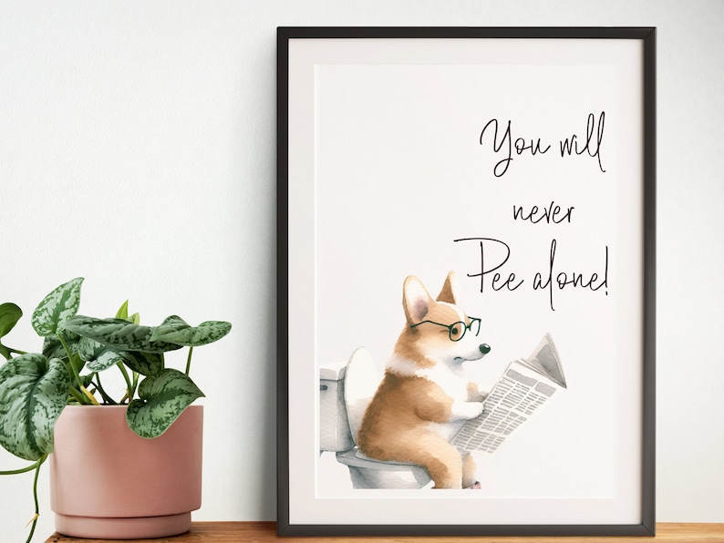 May include: Framed art print featuring a watercolor illustration of a corgi wearing glasses and reading a newspaper while sitting on a toilet. The text reads "You will never Pee alone!"
