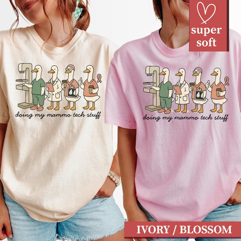 May include: Ivory and pink t-shirts with a graphic of ducks in medical attire operating a mammogram machine. The text "doing my mammo tech stuff" is below the graphic. The shirts are labeled "super soft" and "Ivory / Blossom".