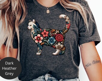 May include: A dark heather grey t-shirt with a white cat illustration. The cat is outlined with floral designs in shades of red, blue, and yellow.