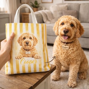 Puede incluir: Un bolso tote personalizado con un patrón de rayas amarillas y blancas. El bolso presenta un retrato de un perro golden doodle con el nombre "Cooper" impreso en el bolso y en el collar del perro. El perro está sentado al lado del bolso.