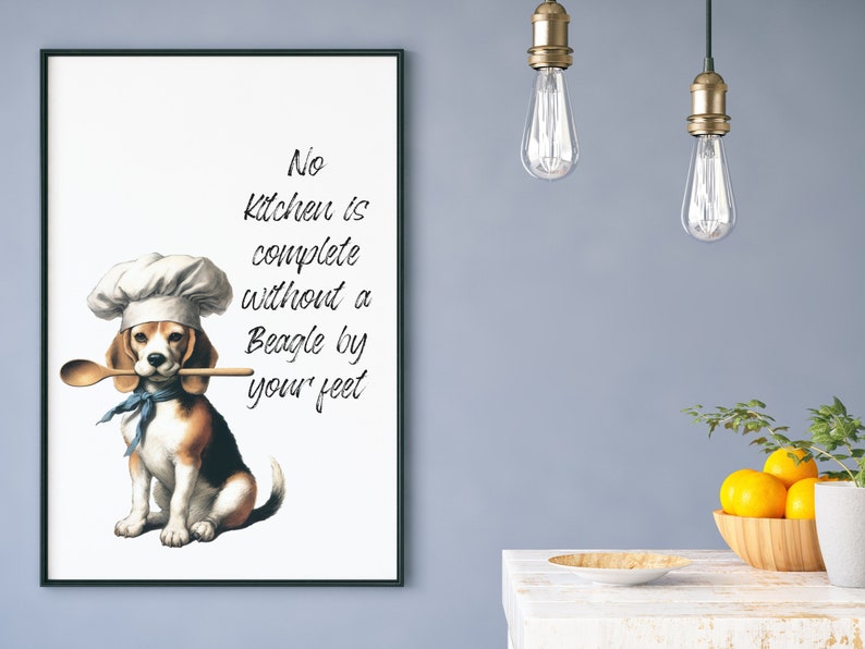K&ouml;nnte beinhalten: Ein wei&szlig;er gerahmter Druck mit einem Beagle, der einen Kochhut tr&auml;gt und einen Holzl&ouml;ffel im Maul h&auml;lt. Der Text auf dem Druck lautet "No kitchen is complete without a Beagle by your feet."