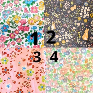 May include: Four fabric swatches with floral and animal patterns. Swatch 1 features a white background with pink, blue, and yellow flowers. Swatch 2 has a dark blue background with bunnies and flowers. Swatch 3 is pink with flowers and leaves. Swatch 4 has a floral pattern.