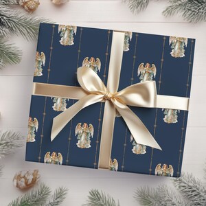 May include: A navy blue gift wrap with a gold ribbon and a repeating pattern of angels with gold halos and wings. The angels are holding a star in their hands.