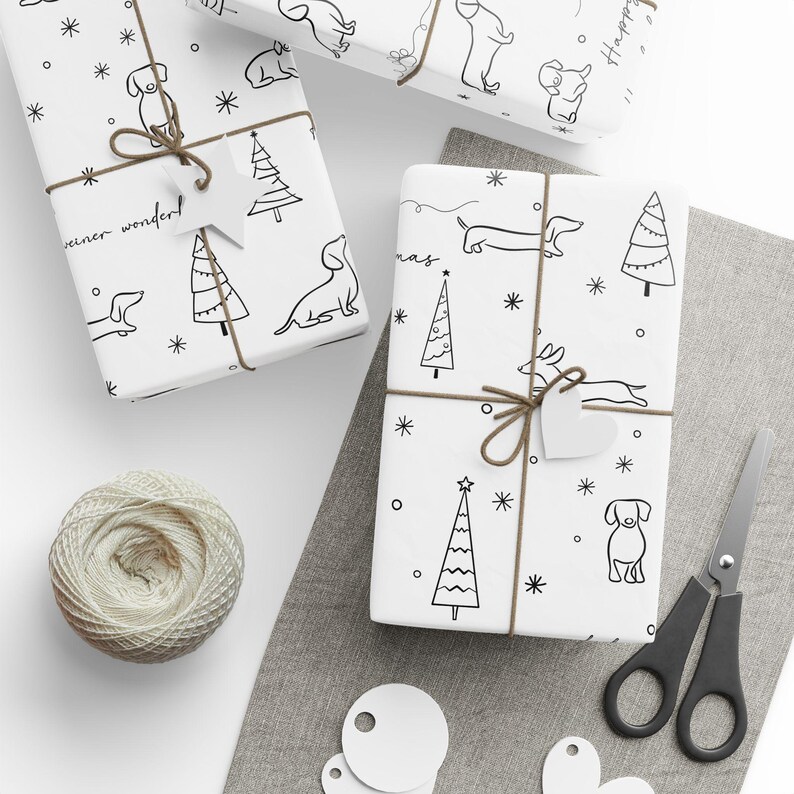 May include: White wrapping paper with a black and white illustration of a dachshund dog, a Christmas tree, and the words "Christmas" and "winter wonder".