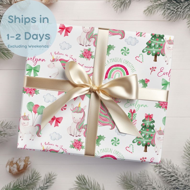 May include: White wrapping paper with a Christmas theme featuring unicorns, candy canes, rainbows, and Christmas trees. The paper has a pink and green colour scheme and the text "A Magical Christmas" is printed on the paper.