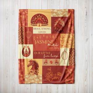 May include: A patchwork blanket in shades of red, gold, and cream, featuring horse illustrations, lanterns, and floral designs. Text includes "Brave, Strong, Loved," "Jasmine Mai," and "Our Little Fire Horse."