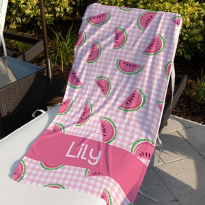 May include: Pink and white checkered beach towel with a watermelon pattern and the name "Lily" printed on a pink banner.