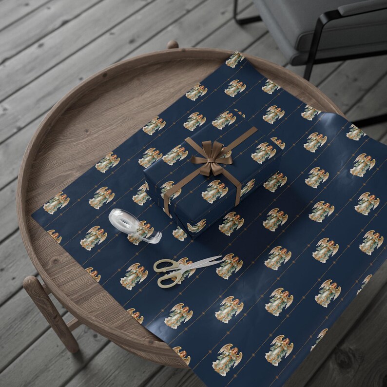 May include: A navy blue wrapping paper with a repeating pattern of angels. The angels are depicted in a vintage style with gold accents. The paper is wrapped around a gift box with a brown ribbon.