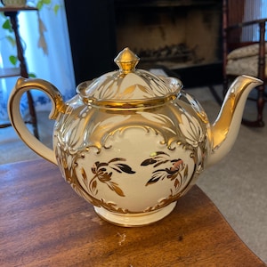 Tetera vintage Sadler England con forma de calabaza, color oro y crema.