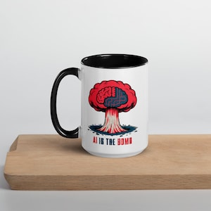May include: White ceramic mug with a black handle and interior. The mug features a graphic of a red brain-shaped cloud with a blue circuit board design. The text "AI IS THE BOMB" is printed below the graphic.