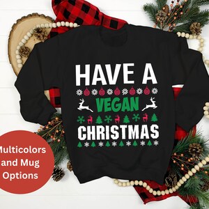 Op de afbeelding: Zwart sweatshirt met een wit, groen en rood kerstontwerp met de tekst "Have a Vegan Christmas".