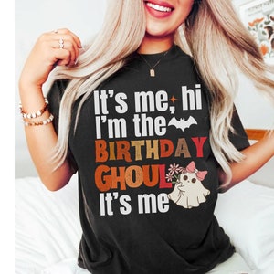 May include: Black t-shirt with a white graphic that says "It's me, hi I'm the birthday ghoul It's me". The graphic also includes a cartoon ghost with a pink bow and flowers.