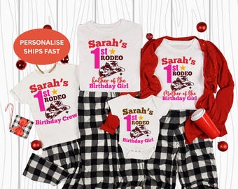 Pode incluir: Um conjunto de camisetas brancas e um body com um gráfico de chapéu de cowboy e o texto "Sarah's 1st Rodeo". As camisas são combinadas com calças de pijama xadrez em preto e branco. Um cardigan vermelho e acessórios completam o conjunto.