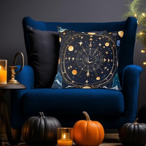 May include: A blue velvet armchair with a throw pillow featuring a celestial design with gold accents. The pillow has a circular pattern with stars, moons, and planets. The armchair is decorated with pumpkins.