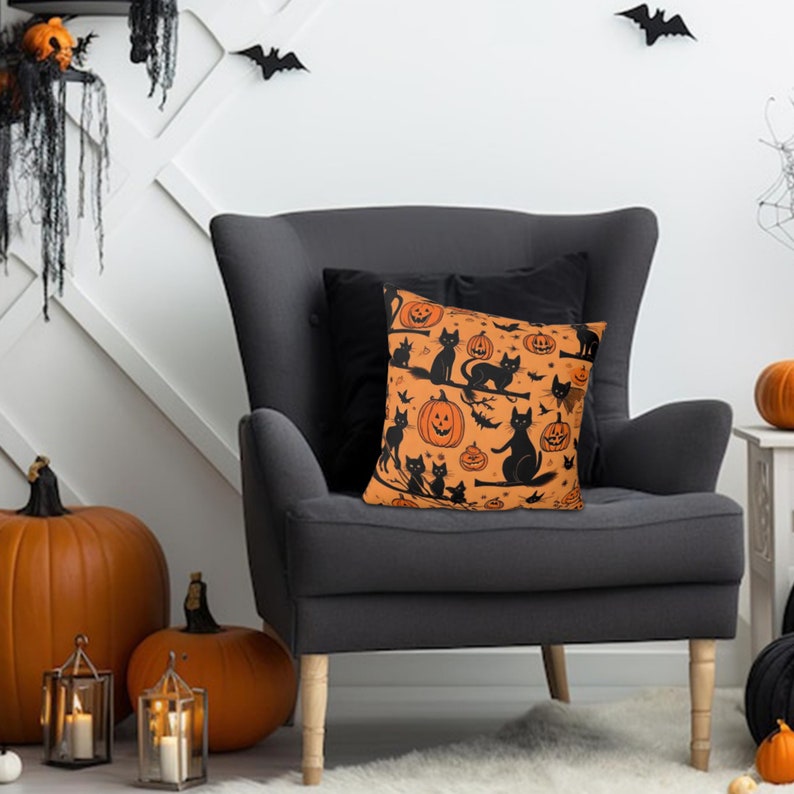 Puede incluir: Una almohada de tiro negra y naranja con un tema de Halloween. La almohada presenta gatos negros y calabazas naranjas con caras de jack-o'-lantern.