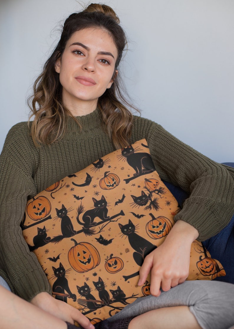 Puede incluir: Una almohada de tiro marr&oacute;n con un patr&oacute;n de tem&aacute;tica de Halloween con gatos negros, calabazas y murci&eacute;lagos. La almohada est&aacute; hecha de una tela suave y felpa y tiene un brillo sutil.