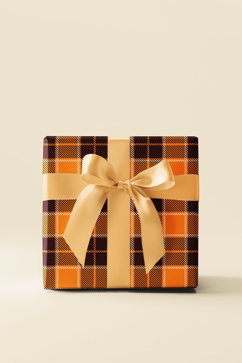 May include: A brown and orange plaid gift box with a gold satin ribbon tied in a bow.