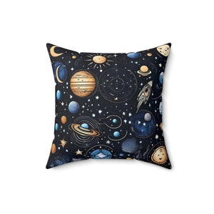 May include: A black throw pillow with a space-themed design. The pillow features a variety of planets, stars, and a rocket ship in shades of blue, gold, and white.