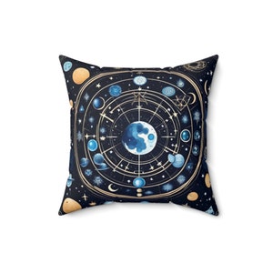 May include: A square throw pillow with a dark blue background featuring a celestial design with gold accents. The design includes a large circle with a crescent moon and stars, surrounded by smaller circles representing planets and celestial bodies.