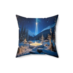 May include: A throw pillow featuring a snowy winter scene with a glowing light in the center of a tree stump. The background shows a dark blue sky with stars and a bright light shining down from the sky.