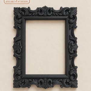 May include: A rectangular black picture frame featuring ornate, raised scrollwork and floral carvings along the border. The top left corner displays a logo with the text The Ember Hollow and the phrase AVAILABLE IN 20 COLOURS.