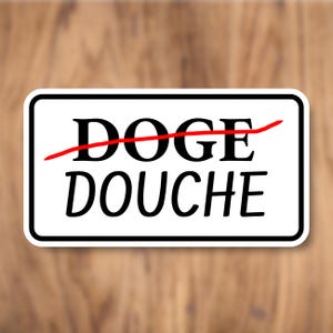 May include: White rectangular sign with a black border. The sign has a red line drawn through the word "DOGE" and the word "DOUCHE" written below it.