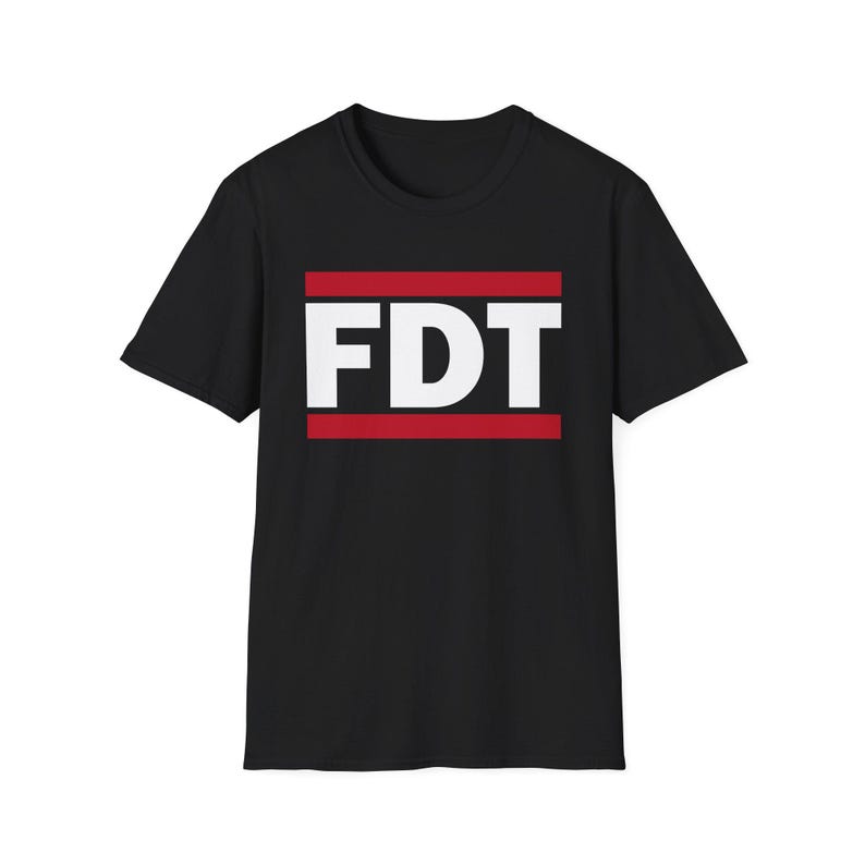 FDT shirt. This is a black tshirt with white text with the letters FDT. There are two red bars one below and one above the text. It is similar to the RUN DMC logo shirts but different enough to be distinct. The FDT on the shirt stands for Fuck Donald Trump or F Donald Trump. It is an anti Trump shirt.