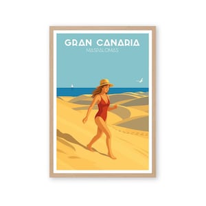 Puede incluir: Una impresión artística enmarcada que representa a una mujer con un traje de baño rojo caminando por una playa de arena. La impresión tiene las palabras "GRAN CANARIA MASPALOMAS" en la parte superior. El fondo muestra dunas de arena, el océano y un cielo azul.