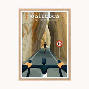 Puede incluir: Un póster de viaje enmarcado que muestra a un ciclista en el Túnel de Sa Calobra en Mallorca. La vista es desde la perspectiva del manillar, mostrando una carretera entre altas paredes rocosas, una señal de tráfico roja y el texto MALLORCA.