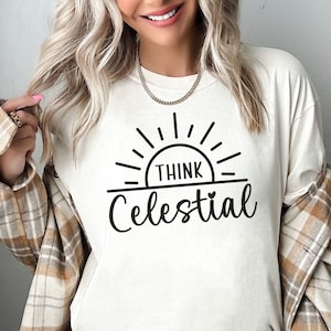 May include: White t-shirt with a black graphic of a sun with the text "Think Celestial" underneath.
