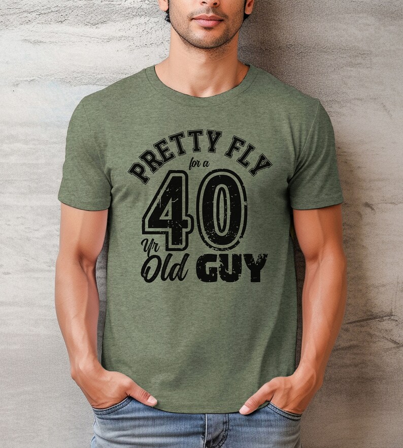 Pu&ograve; includere: Maglietta verde con una grafica nera che dice "Pretty Fly for a 40 Yr Old Guy".