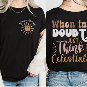 Puede incluir: Camiseta negra con un gr&aacute;fico de sol y el texto "Think Celestial" en la parte delantera. La parte posterior de la camiseta tiene el texto "When in Doubt Just Think Celestial!"
