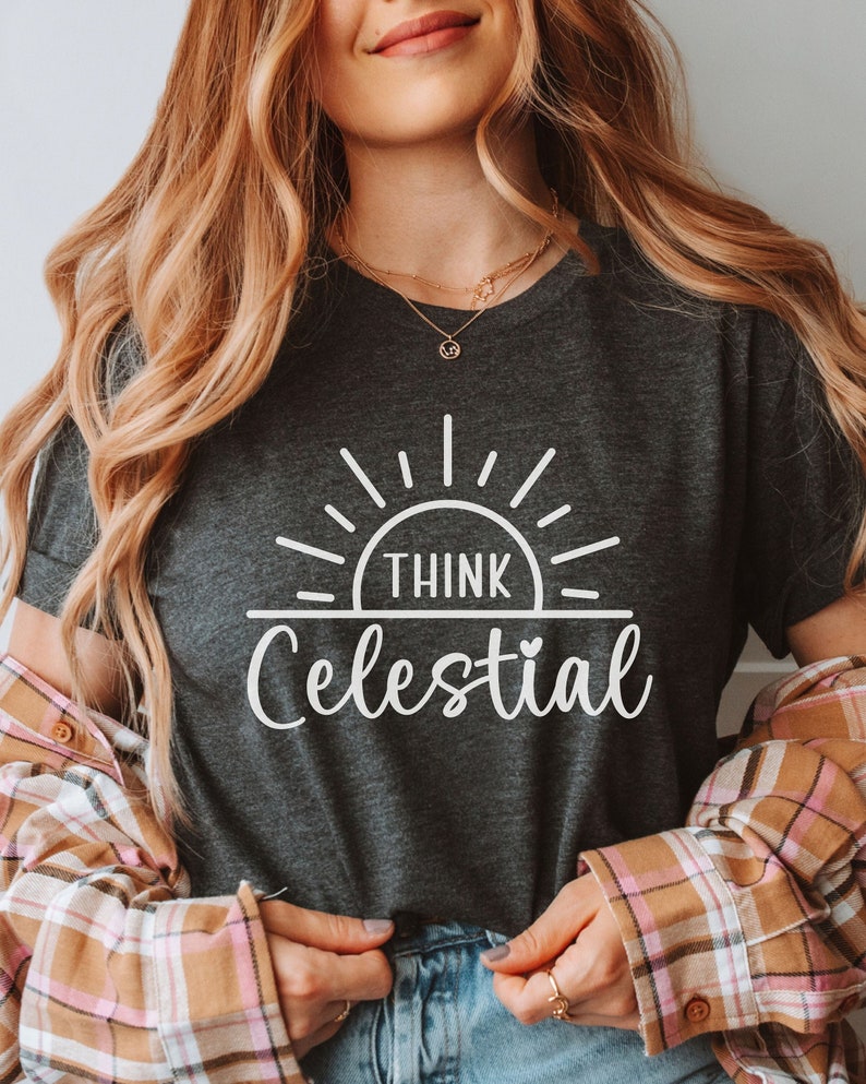 May include: A dark gray t-shirt with a white graphic design of a sun with the text "Think Celestial" underneath.