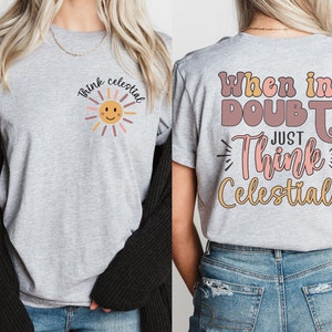 Puede incluir: Dos camisetas grises con un dise&ntilde;o gr&aacute;fico. La camiseta delantera tiene un sol con el texto "Think Celestial". La camiseta trasera tiene el texto "When in Doubt Just Think Celestial!"