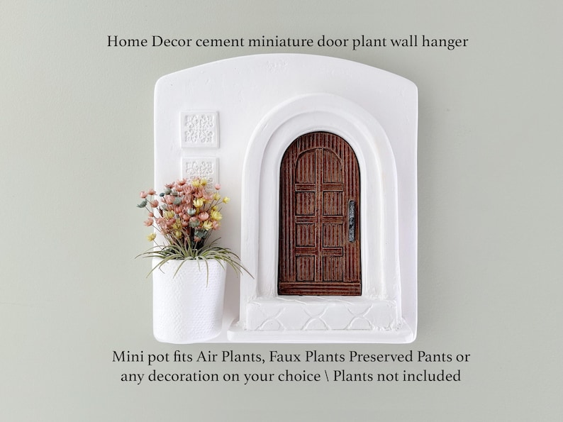 May include: White cement miniature door plant wall hanger with a brown wooden door and a small white pot holding colorful faux plants. The text on the image reads: Home Decor cement miniature door plant wall hanger. Mini pot fits Air Plants, Faux Plants Preserved Pants or any decoration on your choice.