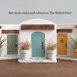 Pu&ograve; includere: Tre scene decorative di porte in miniatura con muri in stucco bianco, finiture marroni e porte colorate. Ogni scena ha una pianta in vaso. Il testo "See more styles and colours at The Potted Door" &egrave; visibile.