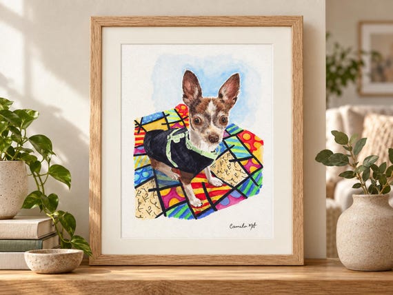 A framed watercolor painting of a brown and white chihuahua wearing a black vest with a light green harness. The dog stands on a colorful, abstract patterned quilt with geometric shapes in blue, yellow, red, and green. Signed by the artist.