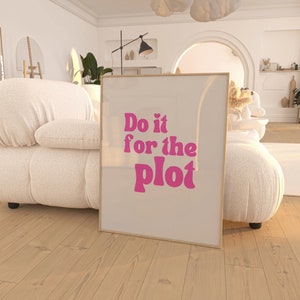以下が含まれることがあります： 白い背景にピンクの文字で「Do it for the plot」と書かれた額装されたプリント