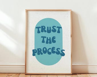May include: A framed print with a blue and white design. The print features a light blue oval with the text "TRUST THE PROCESS" in dark blue.