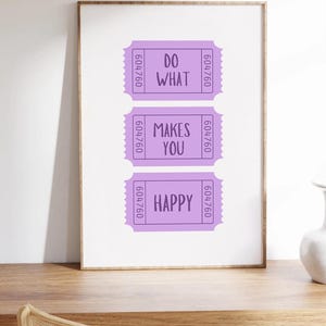 May include: A framed print with three purple ticket-shaped designs. Each ticket has white text that reads "Do What Makes You Happy".