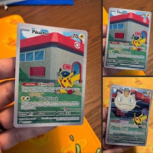 Peut inclure: Trois cartes à collectionner Pokémon avec Pikachu et Miaouss. Les cartes Pikachu montrent un Pikachu jaune en uniforme de facteur devant un bâtiment. Les cartes ont le texte "Error 404" et "Out of Stock".