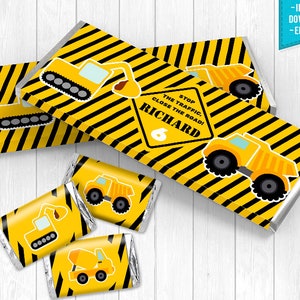 Puede incluir: Envoltorios de barra de chocolate imprimibles con temática de vehículos de construcción. Los envoltorios presentan rayas amarillas y negras, un camión volquete amarillo y el texto "The Stop Traffic Close the Road! Richard 6".