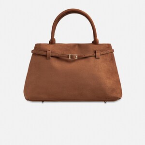 Puede incluir: Un bolso marr&oacute;n con asa superior y forma rectangular. El bolso presenta un detalle de cintur&oacute;n con hebilla dorada. El bolso est&aacute; hecho de un material similar al ante.