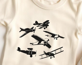 May include: A white baby t-shirt with a black silhouette of five different airplanes printed on the front.