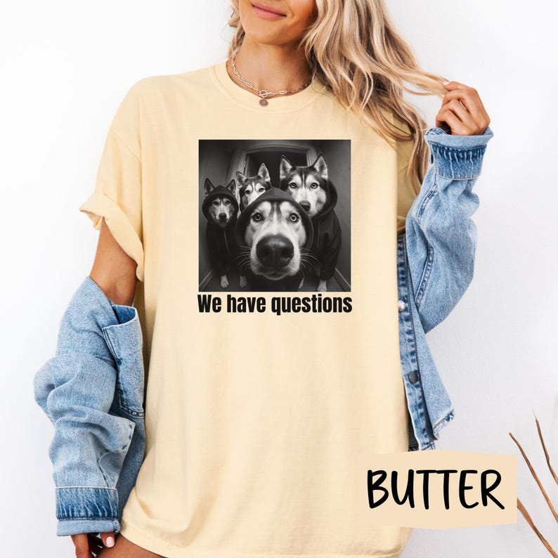 May include: Pale yellow t-shirt with a black and white image of four Huskies in hoodies, with the text "We have questions." The word "BUTTER" is printed in a yellow rectangle at the bottom.