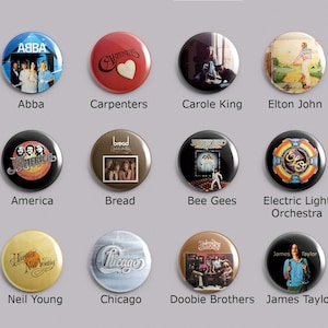May include: A collection of twelve round pinback buttons featuring album art and band names. Bands include ABBA, Carpenters, Carole King, Elton John, America, Bread, Bee Gees, Electric Light Orchestra, Neil Young, Chicago, Doobie Brothers, and James Taylor.
