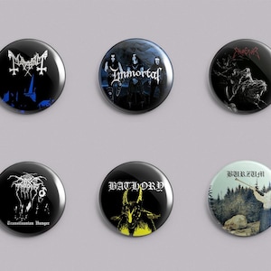 May include: A set of six circular pin-back buttons featuring black metal band logos and album artwork. The designs include Mayhem, Immortal, Emperor, Darkthrone with Transilvanian Hunger text, Bathory with a yellow goat graphic, and Burzum.
