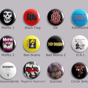 May include: A collection of twelve circular pin-back buttons featuring various punk rock band logos and graphics. The designs include Misfits, Black Flag, Dead Kennedys, Adolescents, Bad Brains, D.R.I., Descendents, Negative Approach, Suicidal Tendencies, and Circle Jerks.