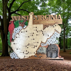 May include: Wooden West Virginia State Parks sign. The sign is shaped like the state, with a detailed map and illustrations of a cardinal, butterfly, and bear. The sign includes the text "West Virginia State Parks."