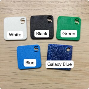 Puede incluir: Cinco muestras de color cuadradas en blanco, negro, verde, azul y azul galaxia. Cada muestra tiene una esquina redondeada y un agujero. Los colores est&aacute;n etiquetados con texto blanco sobre un fondo blanco: Blanco, Negro, Verde, Azul y Azul Galaxia.